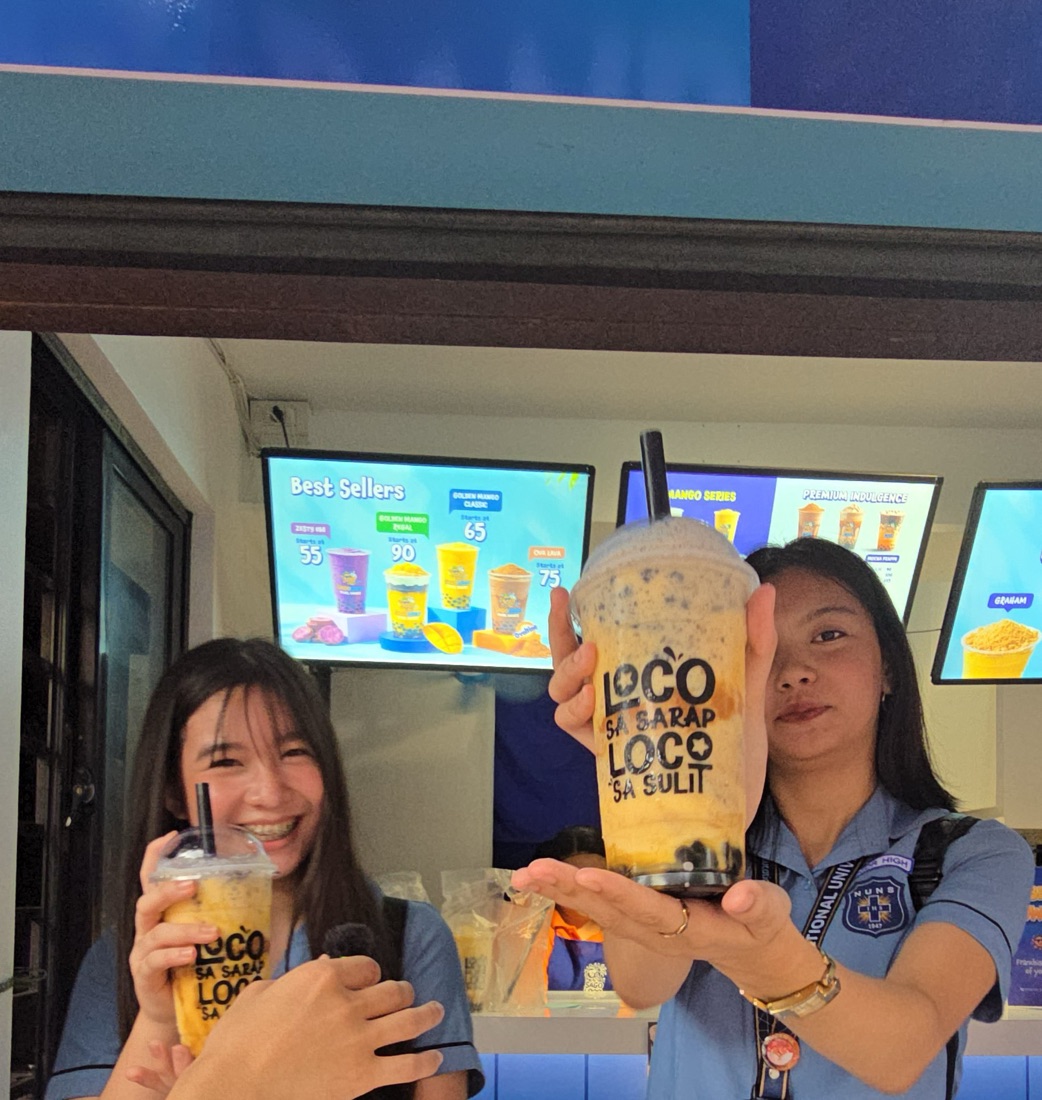 Two students holding Sago Loco Mango Regal shakes